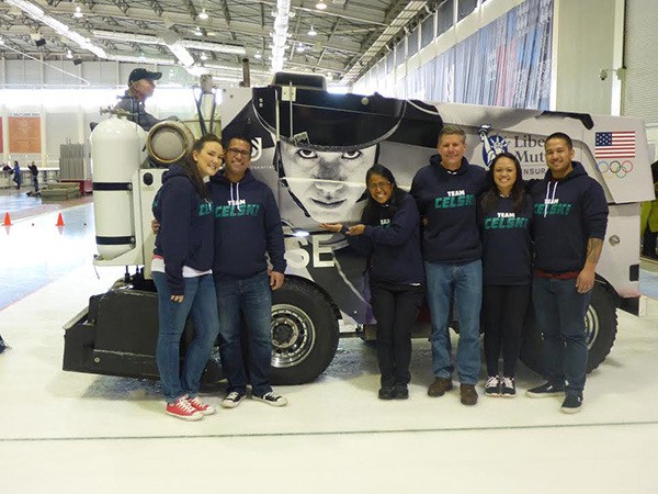 Speedskating Olympian J.R. Celski’s family members pose for a photo with Celski’s picture on the side of a vehicle.
