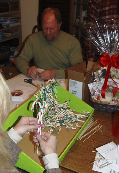 Doug Hoggard and Cindy Jury work on gift baskets as part of a project for Federal Way Vineyard Fellowship.