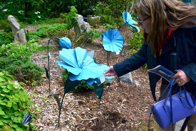 Federal Way City Councilwoman Susan Honda checks out a blue poppy during Blue Poppy Day on Saturday.