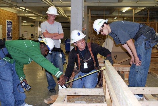 Instructor Kurt Kurtz (center) shows students in the YouthBuild program about measuring angles. From left to right is D’Vonte Ashford