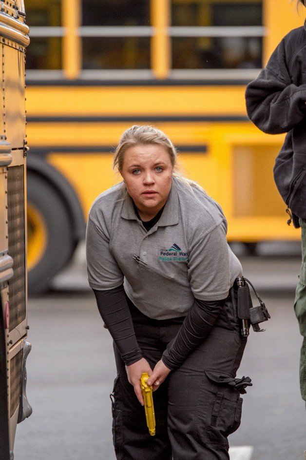 A member of the Federal Way Police Explorers shows off her law enforcement skills during the 14th annual Police Explorer challenge in Federal Way on Saturday. The scenario involved dealing with terrorists on a bus with hostages.