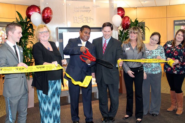 Federal Way Mayor Jim Ferrell (fourth from left) and BECU branch manager Rakesh Naidu (holding scissors) cut a ribbon during a grand opening celebration of the bank’s new location.