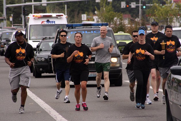 Officers from the Federal Way Police Department move the Special Olympics Summer Games torch through the city on Friday