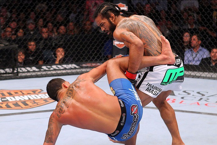 Decatur High School graduate Benson Henderson takes down Anthony Pettis during Saturday's UFC 164 title fight in Milwaukee. Pettis took Henderson's belt with an armbar in the first round.