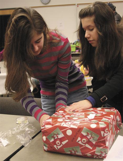 Meghan McMullen of Tacoma and Monique Preston of Burien wrap gifts Tuesday at the fire station.