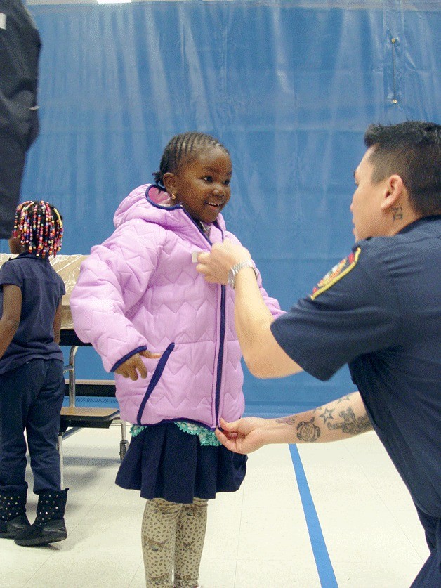 A South King Fire and Rescue firefighter helps zip a Wildwood Elementary student's new coat. South King County Professional Firefighters (IAFF Local 2024) and South King Firefighters Foundation recently provided students with new coats.