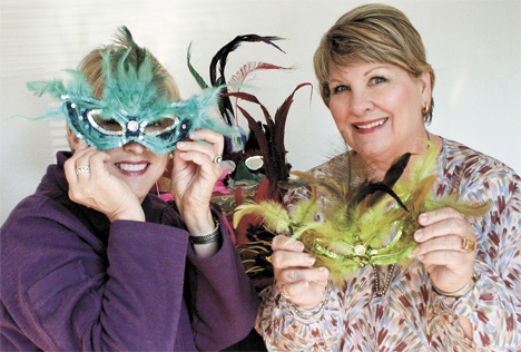 Federal Way Symphony board president Kathy Franklin (left) and symphony Fall Gala chairwoman Glenna Cameron try on masks for the symphony's Oct. 17 'Come to the Masquerade' Fall Gala
