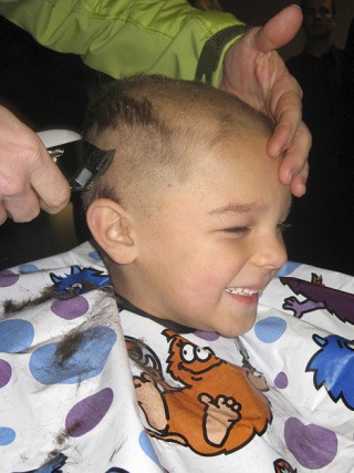 6-year-old Tristian Gross smiles as he gets his head shaved Dec. 5.
