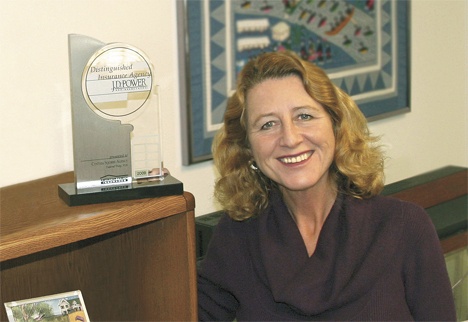 Federal Way's American Family Insurance agent Cynthia Squires proudly displays her agency's Distinguished Insurance Agency award from J.D. Power and Associates for customer satisfaction excellence.