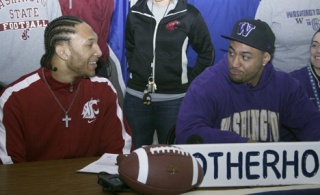 Federal Way High School football players Andre Barrington (left) and Andru Pulu joke around during a ceremony Wednesday inside the school's cafeteria. The pair had just signed their national letters of intent to play football in the fall. Barrington
