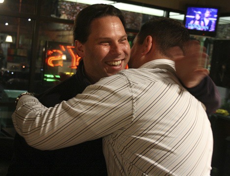 Federal Way City Council member Jim Ferrell gets a hug from his friend and campaign manager Steve McNey on Nov. 3 at Marista's coffee.