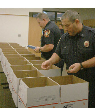 Sven Schievink and Scott Ervin of South King Fire and Rescue prepare care packages to send to the 110-person Army National Guard 81st Brigade Heavy Combat Team unit that includes Robert Bryant