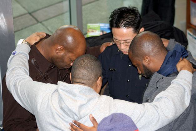 Federal Way police Chief Andy Hwang (center) prays with members of various local congregations and the greater community during a prayer rally that was held in City Hall's lobby on Wednesday.