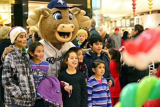 A group of kids pose for a photo with the Tacoma Rainiers' mascot