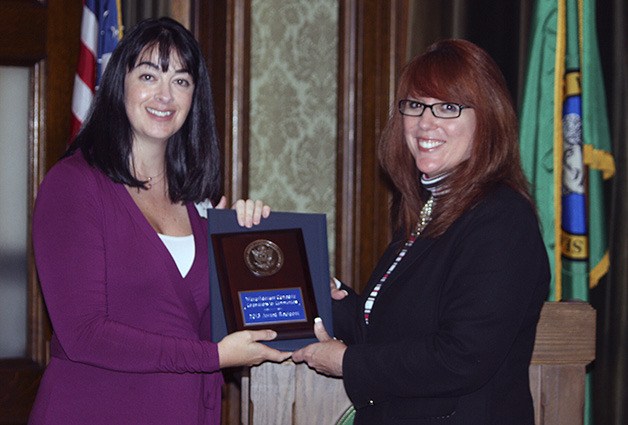 Secretary of State Kim Wyman presents Weyerhaeuser’s Kristen Sawin with the Corporations for Communities award.