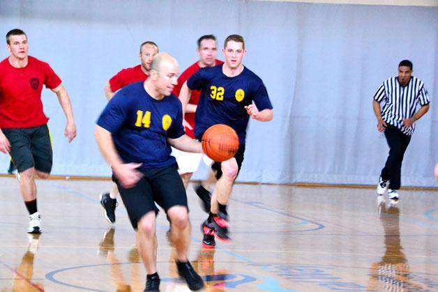 A Federal Way Police Department official dribbles the ball during a game between police and South King Fire and Rescue on Saturday at the Federal Way Community Center.