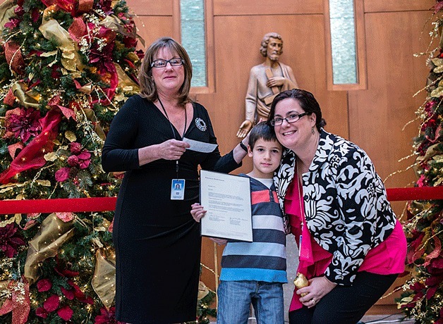 Orion Haury and his mother Jennifer receive a letter of recognition from Tricia Sinek