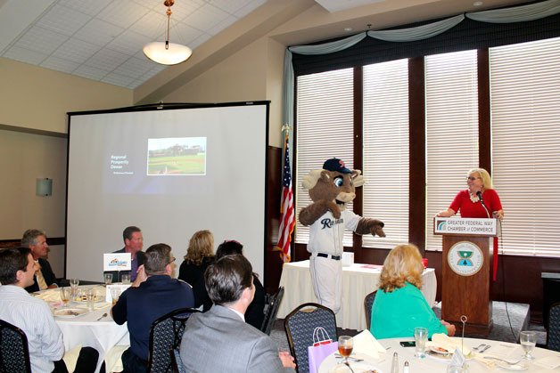 Rainer’s Baseball mascot Rhubarb dances near Chamber CEO Rebecca Martin at the State of the Chamber luncheon on Wednesday.
