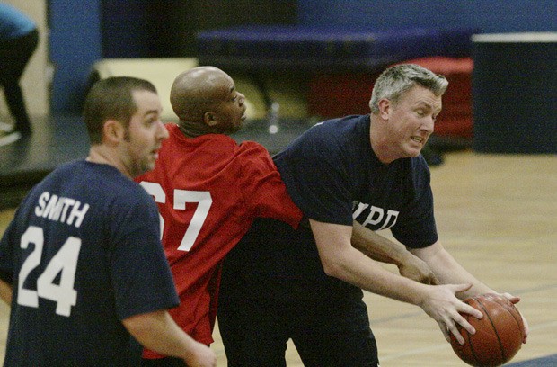 Federal Way police Lieutenant Kurt Schwan attempts to get away from a defender during Saturday’s Federal Way Lions Helen Keller Day Basketball Challenge at Decatur.