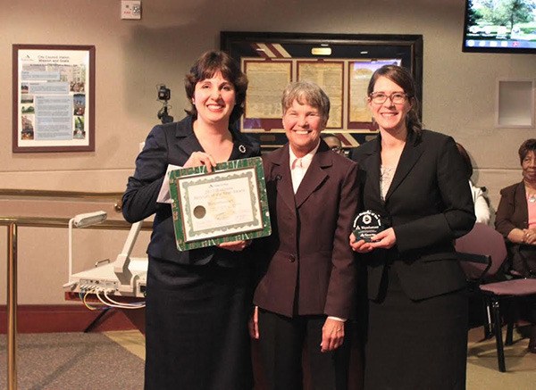 Weyerhaeuser's Laura Ramon (left) and Ara Erickson (right) accept awards for being the Recycler of the Year from Federal Way City Councilwoman Dini Duclos (center) Tuesday night.