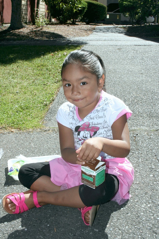 A girl enjoys lunch at Parkway Apartments in Federal Way recently as part of Federal Way Public Schools’ summer meal program