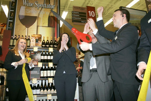 Federal Way City Councilmember Kelly Maloney (center) and Total Wine officials celebrate the grand opening of the new business with a ribbon-cutting ceremony on Thursday.