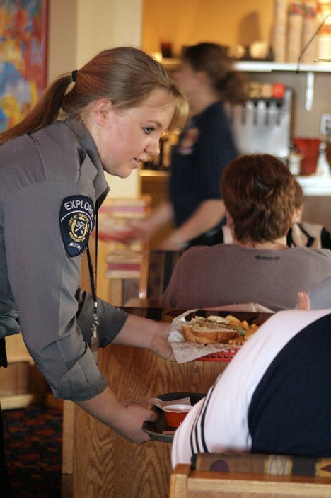 Federal Way Police Explorer Heidy Wells serves food to patrons Saturday during the Red Robin Tip-A-Cop fundraiser in support of Special Olympics Washington.
