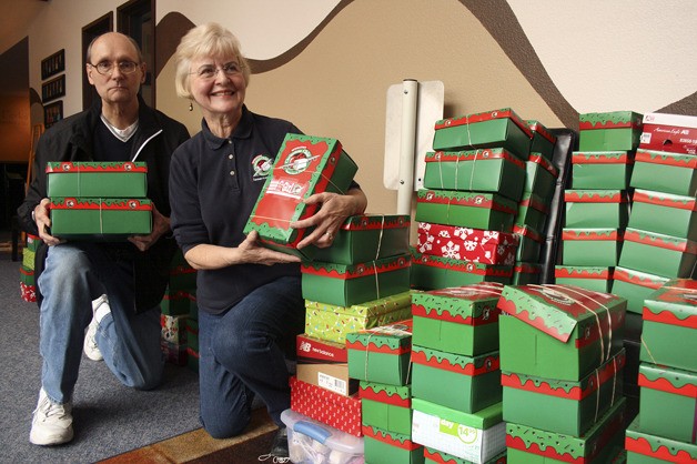 Federal Way volunteers Betty Bjorklund and George Hagerhjelm with a stack of shoeboxes Monday at Our Savior’s Baptist Church.