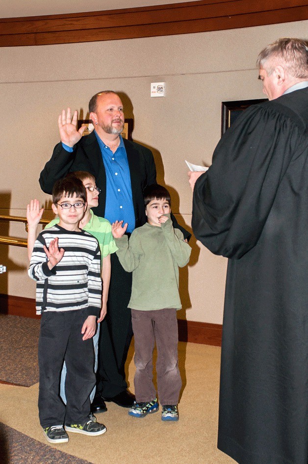 Geoffrey McAnalloy takes the oath of office as he is sworn in on Dec. 10 as a member of the Federal Way Public Schools Board of Directors. Also pictured are McAnalloy’s children.