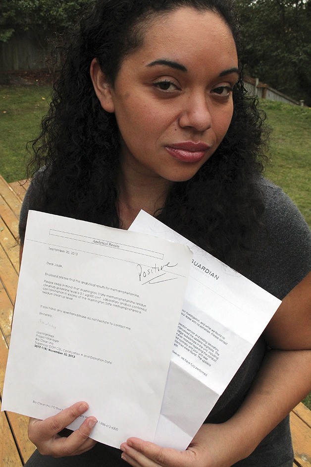 Jade Winslow-Fuentez holds two pieces of paper: one that confirms a positive test for meth residue in her former apartment