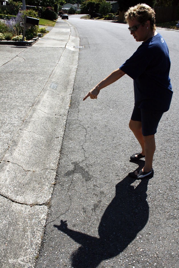 Sandra Bagnuk points out cracks along the streets and sidewalks in her portion of Twin Lakes. Bagnuk said she noticed the cracks were expanding and deepening. “I don’t want to blame it on the heat