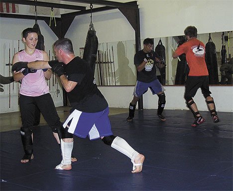 Instructor Rich Parker helps student Marcella Fogg at Northwest Kickboxing and Mixed Martial Arts in Federal Way.