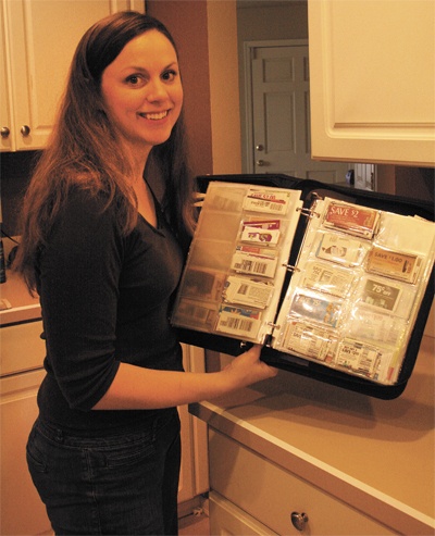 Angela Russell stands with her binder full of coupons. By using coupons