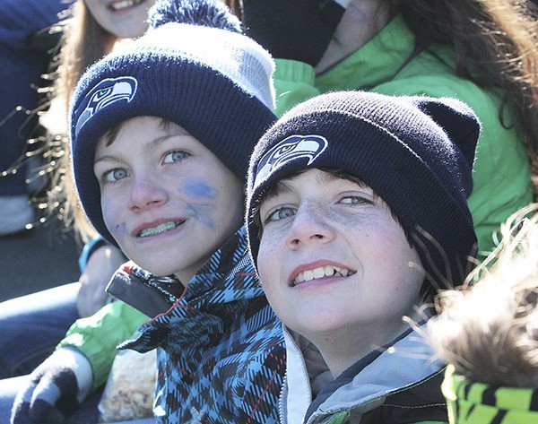 Andy (left) and Isaac Olson sit at the Seattle Seahawks victory parade Wednesday afternoon in downtown Seattle. They were two of an estimated 700