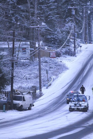 Federal Way police close South 336th Street on Thursday morning after a van slides in the snow and into a utility pole