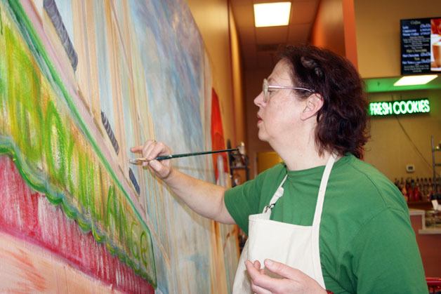 Federal Way artist Hester Mallonee paints her favorite street in Paris onto an 8-foot long canvas at Ma Boulange Bakery