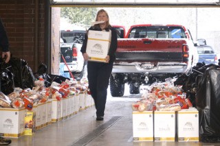 South King Fire and Rescue spokeswoman Donna Conner prepares a box of food to deliver to needy families Dec. 22. Boxes of food and bags of toys waited at SKFR's headquarters in Des Moines to be delivered through the district's annual Community Food and Toy drive.