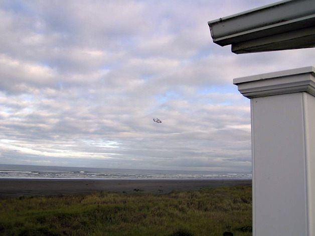 A Coast Guard helicopter searches Monday morning for a Federal Way fisherman who was presumed missing near Ocean Shores. The body of another Federal Way fisherman was recovered Sunday.