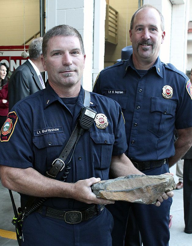 South King Fire and Rescue's Lt. Chris Burdyshaw holds a rock that Lt. Scott Mahlen (right) brought back from the crash site in Shanksville
