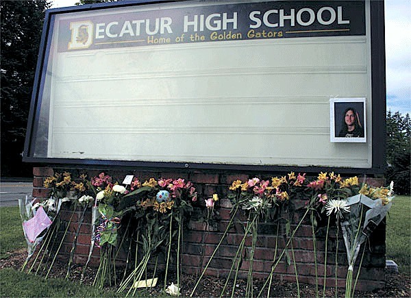 Flowers and messages were placed at Decatur High School’s billboard along South 320th Street for three students involved in a fatal crash in 2010. Two of the students died.