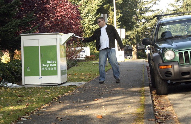 A Federal Way voter deposits a ballot in the drop-off box Tuesday morning next to City Hall on 8th Avenue South.