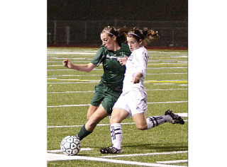 Beamer’s Linsey Richou (left) battles with Kentwood’s Laura Moore for the ball during Wednesday’s SPSL girls soccer title match at Federal Way Memorial Stadium. Kentwood won the game