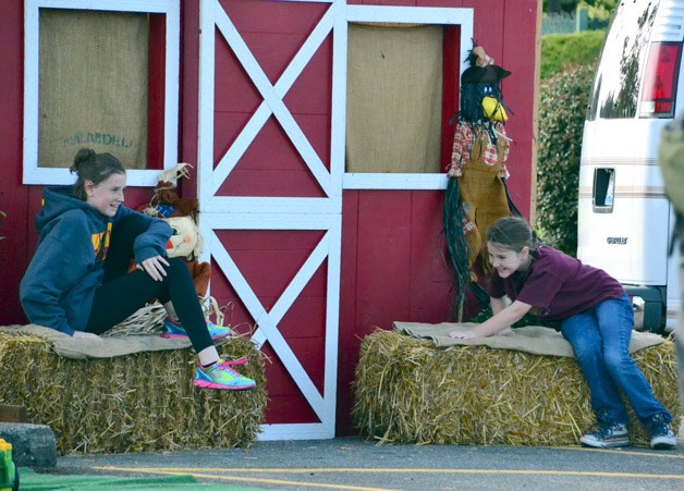Two girls have fun on bales of hay during the Apple Festival on Saturday at the Federal Way Farmers Market.