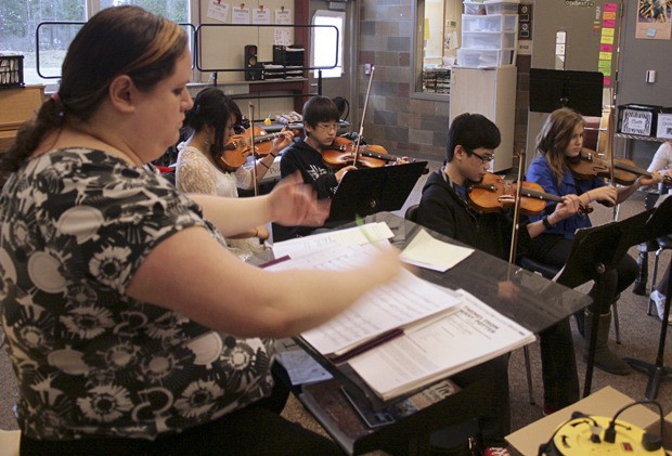 Sequoyah orchestra teacher Rebecca Pomeroy conducts the Phoenix Orchestra. Pictured (left to right) are violinists Eloisa Serrano