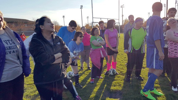 The Federal Way Special Olympics soccer team gather before practice on April 15 and laugh at one of coach Snow’s many jokes. Practices are held on the Saghalie Middle School grass field in the evenings during the week.
