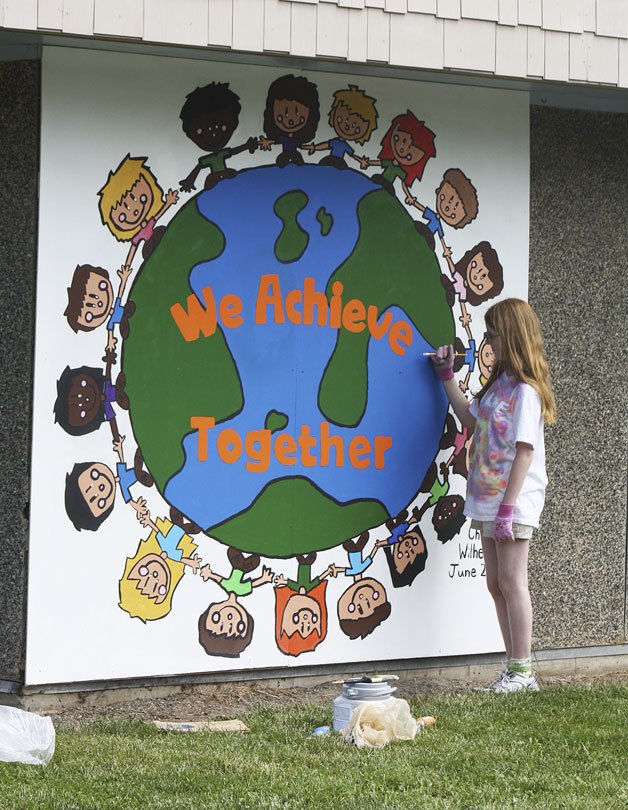 Twin Lakes Elementary School fifth-grader Chloe Wilhelm puts some touchups on a mural she designed for the school on Saturday.