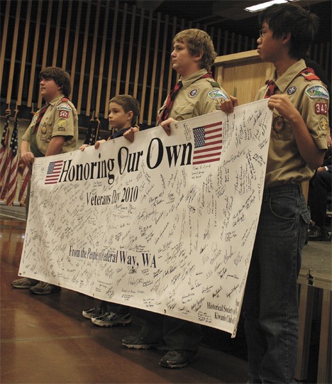 Boy Scouts hold a banner with dozens of local signatures at the 2010 'Honoring Our Own' Veterans Day observance.