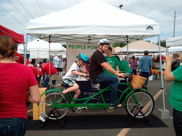 A family rides a bicycle through the Federal Way Farmer's Market during the annual Family Safety Day in 2013. This year's event is set for July 19.