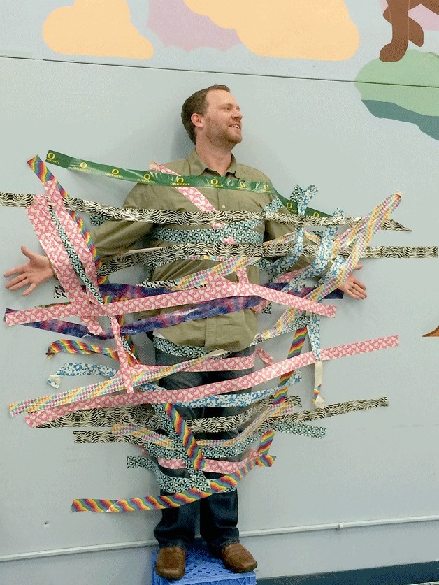 Olympic View Elementary students taped principal Paul Marquardt to the wall during a recent assembly as a reward for reaching their reading goal.