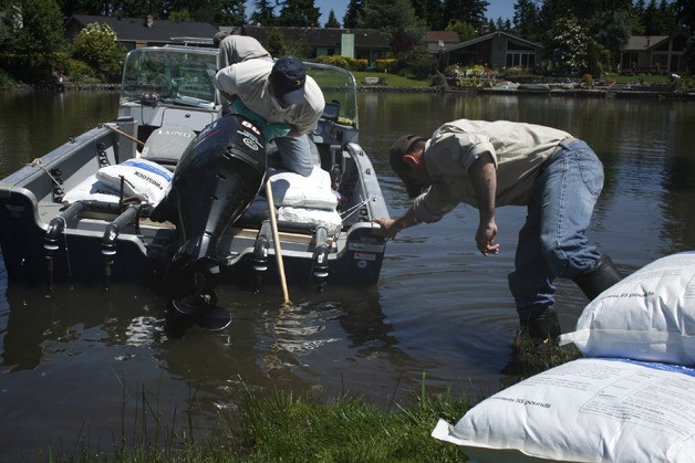 Aquatic biologists apply a chemical to remove phosphate from Lorene Lake in the Twin Lakes neighborhood.